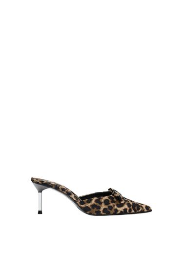 Leopard print slingback court shoe with a pointed toe, front bow detail, and a metallic stiletto heel on a white background.