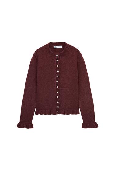 Front view of a burgundy jacket with a round neck, long sleeves, and ruffles. Front button fastening.