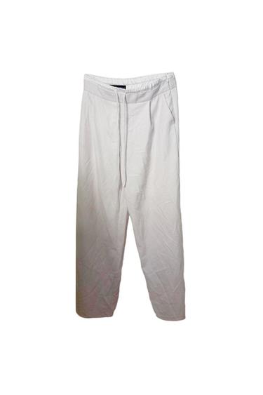 White straight-leg trousers with an elasticated drawstring waist, displayed on a white background.