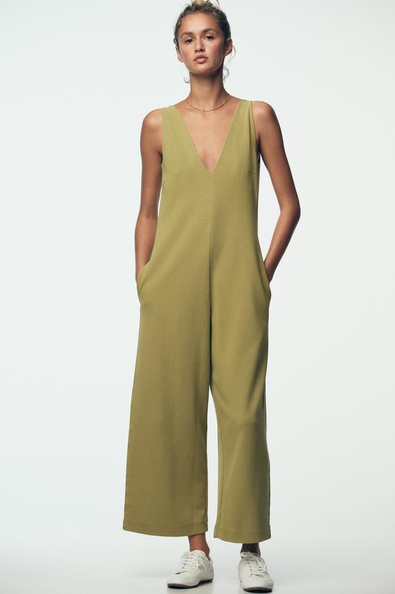 Olivově zelený overal bez rukávů s výstřihem do V, širokými nohavicemi a bočními kapsami.