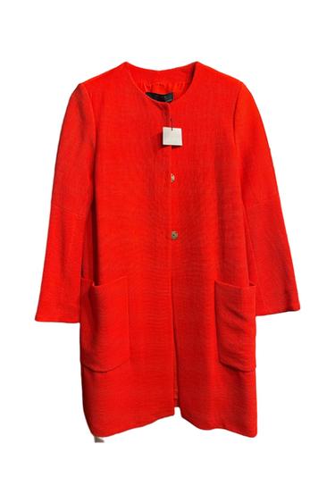 Bright red coat with a round neck, two large pockets, and button closure. Visible hangtag on the collar.