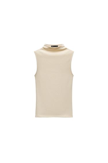 Front view of a cream-coloured sleeveless top with a high neck