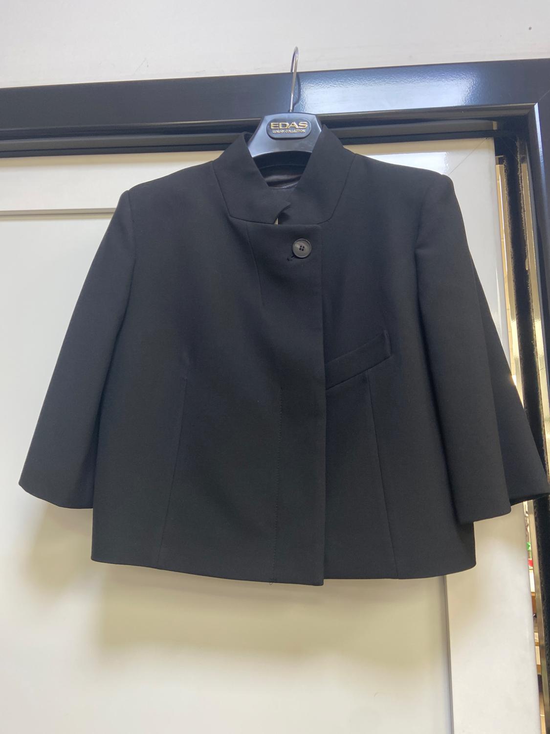 Black high-neck jacket with one button and three-quarter sleeves, hanging on a hanger bearing the text “EDAS LUXURY COLLECTION”.