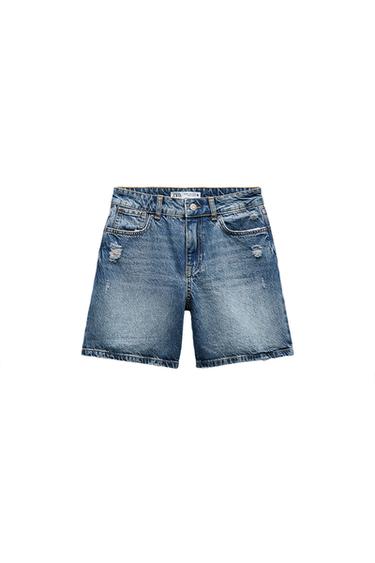 Front view of denim shorts with front pockets and distressed detailing.