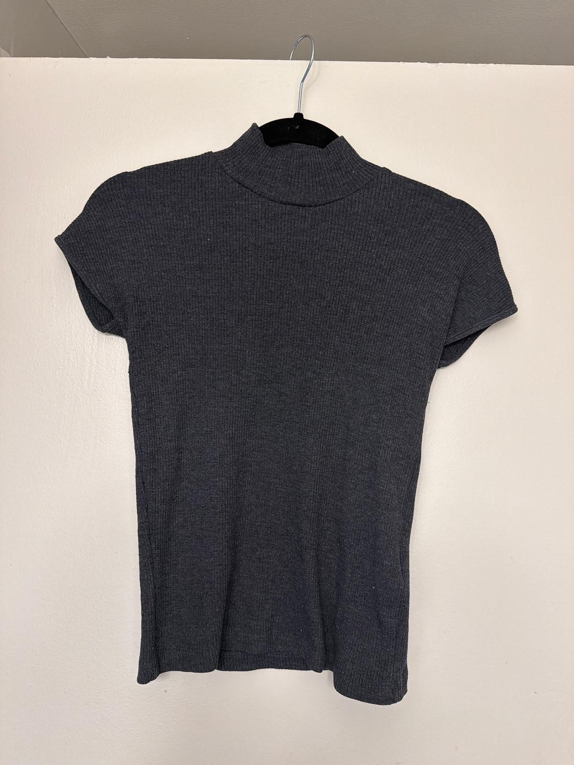 Grey, short-sleeved, roll-neck jumper hanging on a black hanger against a white wall.