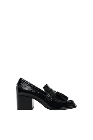 Black patent leather loafer with a chunky heel and tassels, photographed in profile against a white background.