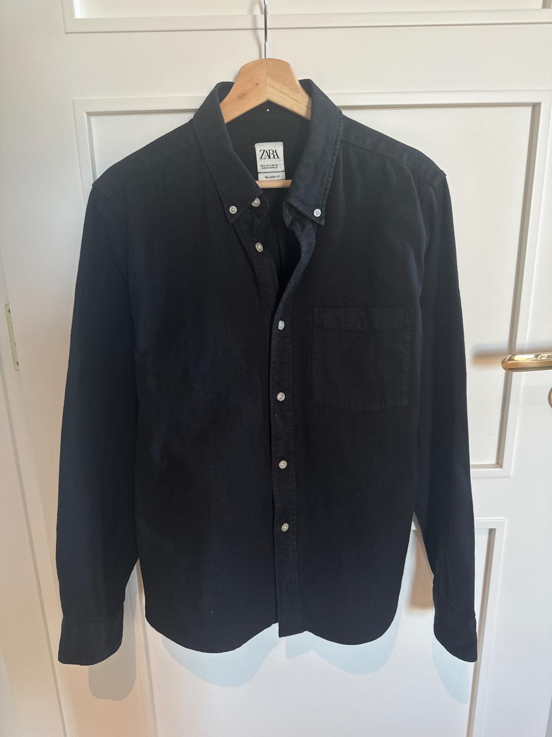 Front view of a black button-up shirt with a chest pocket.