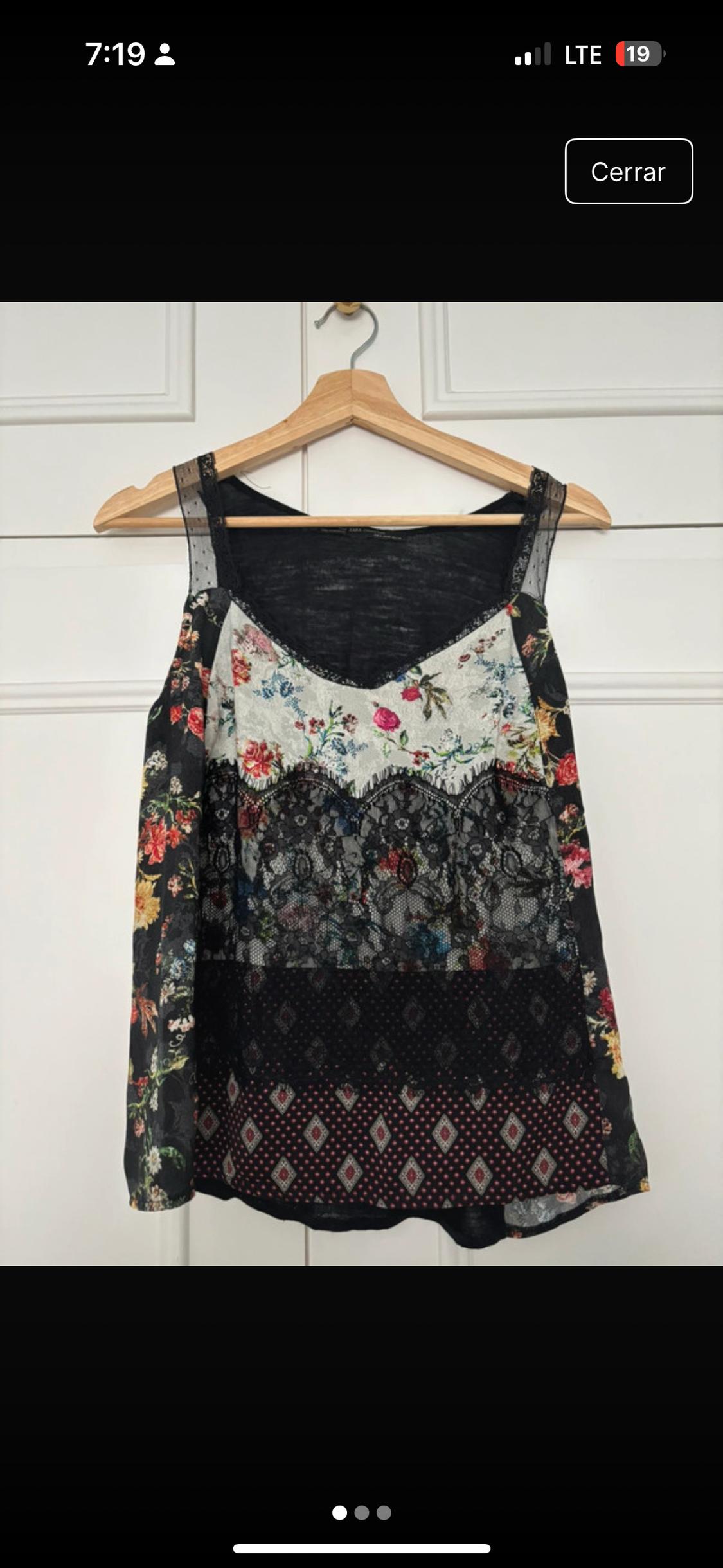 Front view of a sleeveless blouse with a floral print and black lace.