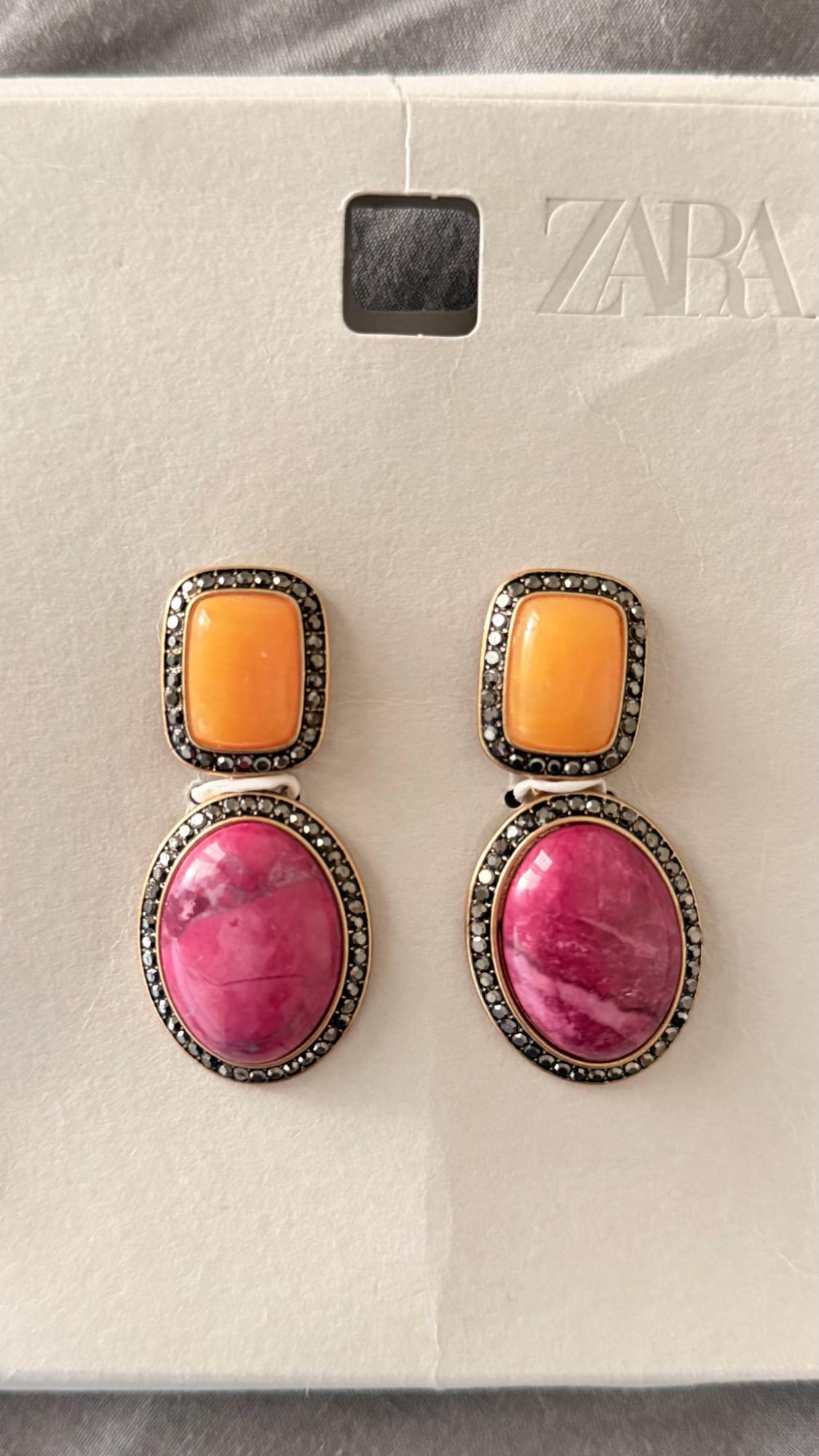 Earrings with an orange upper stone and an oval pink lower stone with a dark border. Presented on card bearing the text ZARA.