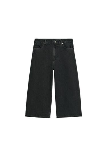 Front view of black, mid-rise Bermuda shorts with five pockets and a front zip and metal button fastening.