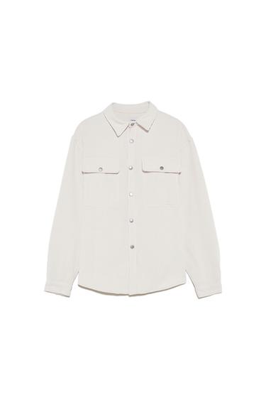 Front view of beige shirt with front pockets and silver buttons.