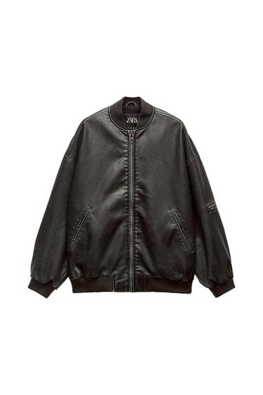 Black bomber jacket with front zipper and slanted pockets. Elastic collar, cuffs, and hem. Visible tag: ZARA.