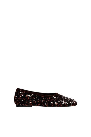 Side view of a black flat shoe with shiny sequins.