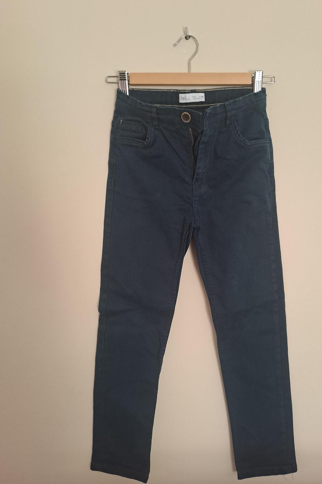 Front view of dark blue trousers with side pockets and a visible button.