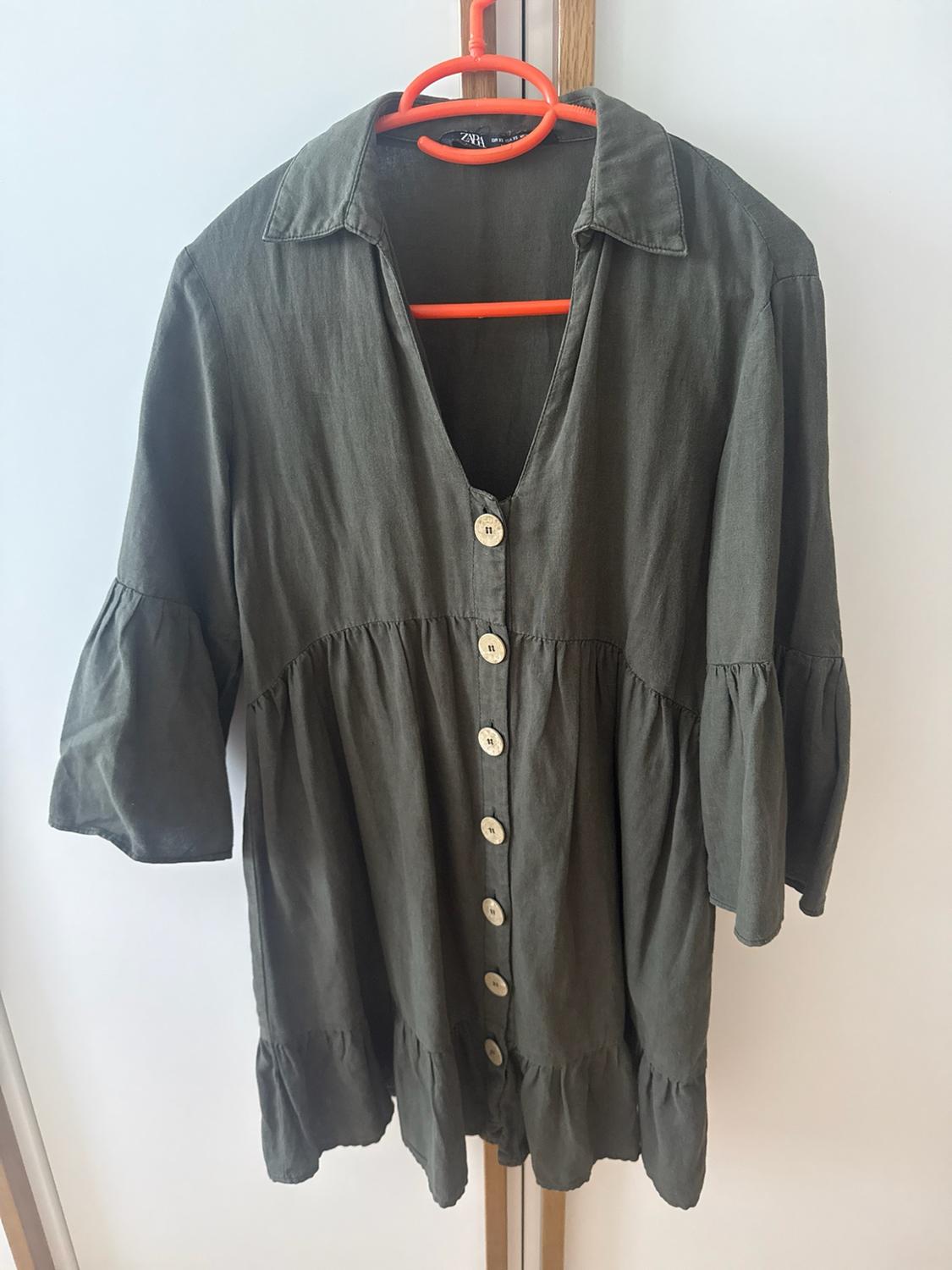 Dark green ZARA dress on an orange hanger. Design with a lapel collar, V-neckline, front buttons, sleeves and frilled hem.