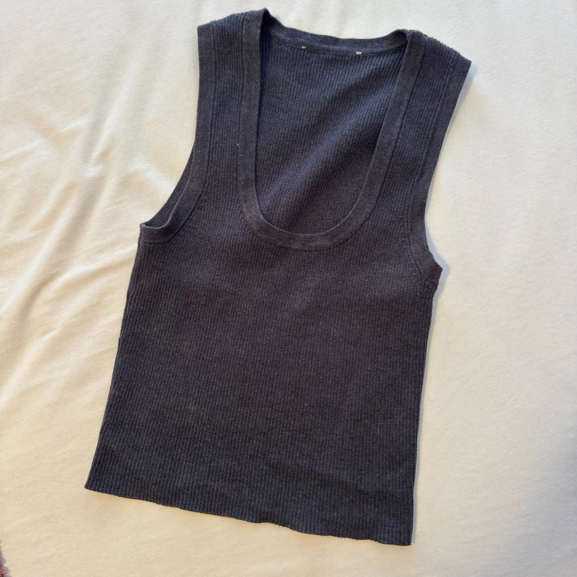 Dark grey ribbed sleeveless scoop neck top, set against a light-coloured fabric surface.