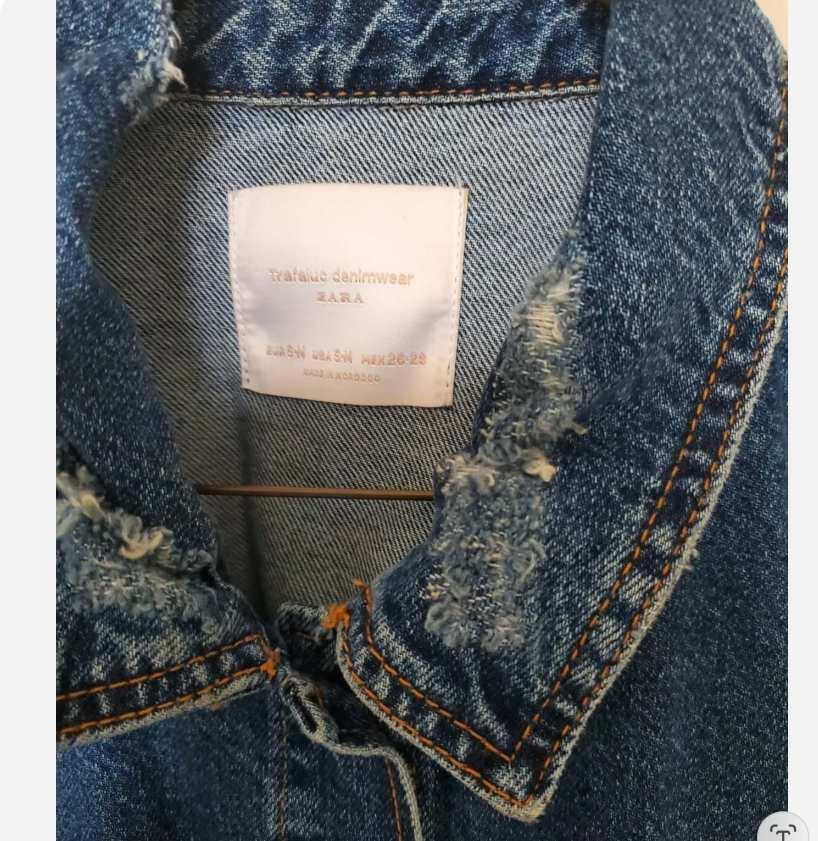 Detail of a denim jacket collar with a visible label that reads 'TRAFALUC DENIMWEAR ZARA'.