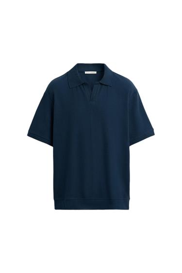 Navy blue short-sleeved polo shirt with a ribbed texture and classic collar, on a white background.