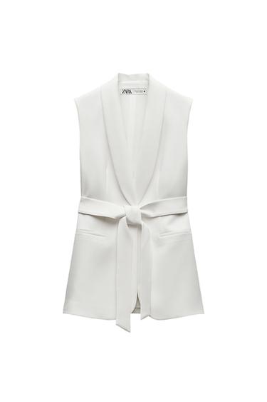 Front view of a white sleeveless waistcoat with lapels and a belt, front pockets.