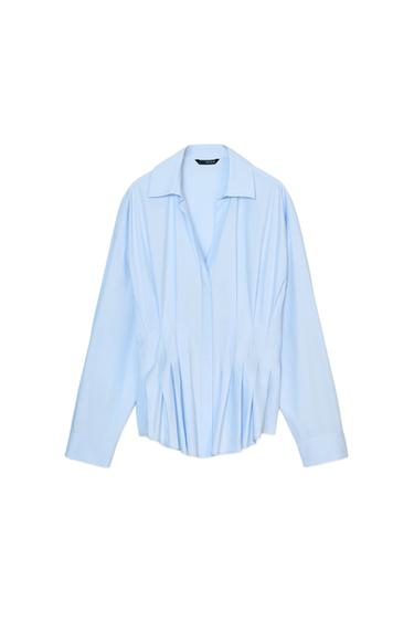 Front view of a light blue shirt with a lapel collar, V-neck, long sleeves, and pleats at the waist. Concealed buttons.