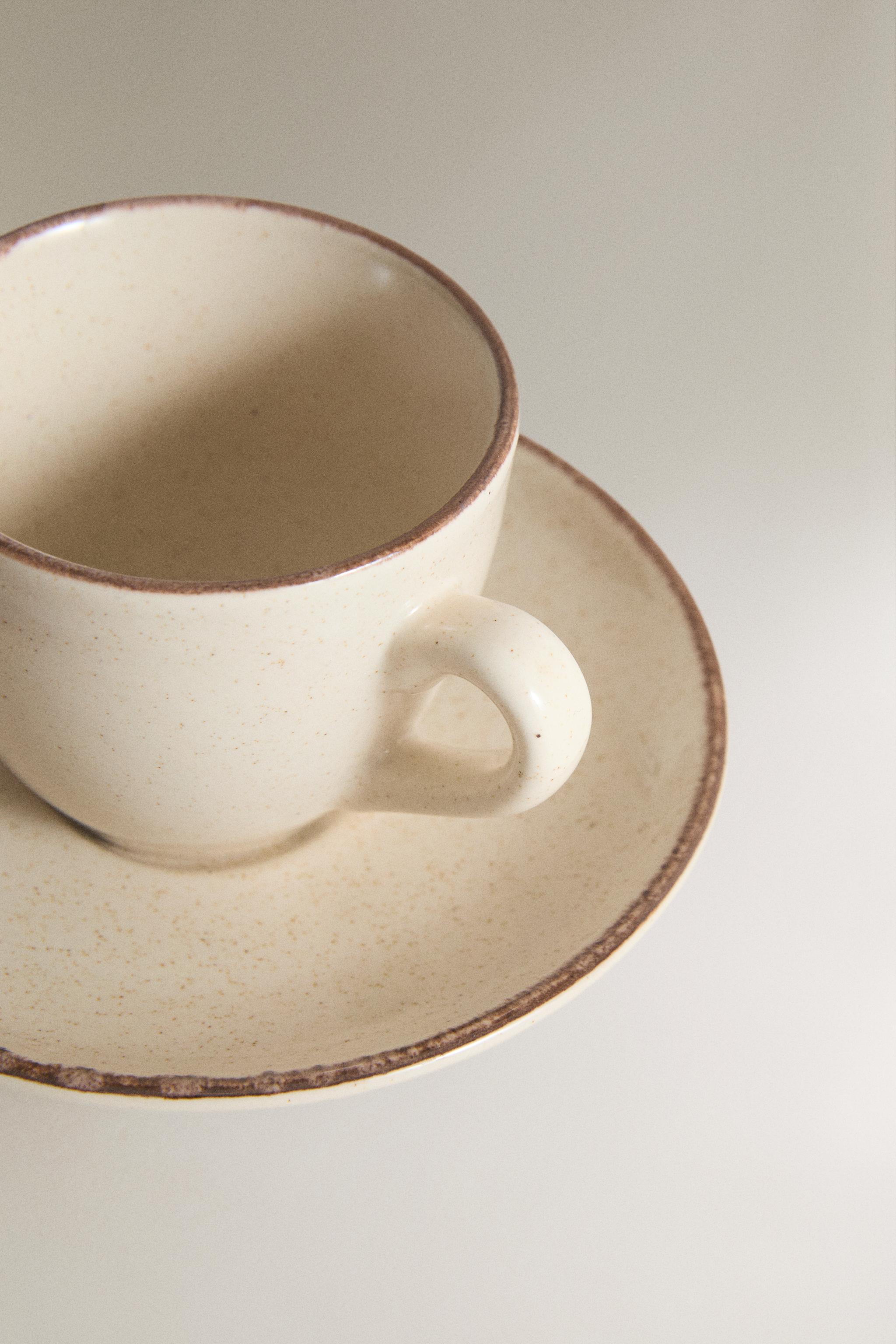 STONEWARE COFFEE CUP AND SAUCER WITH DISTRESSED RIM