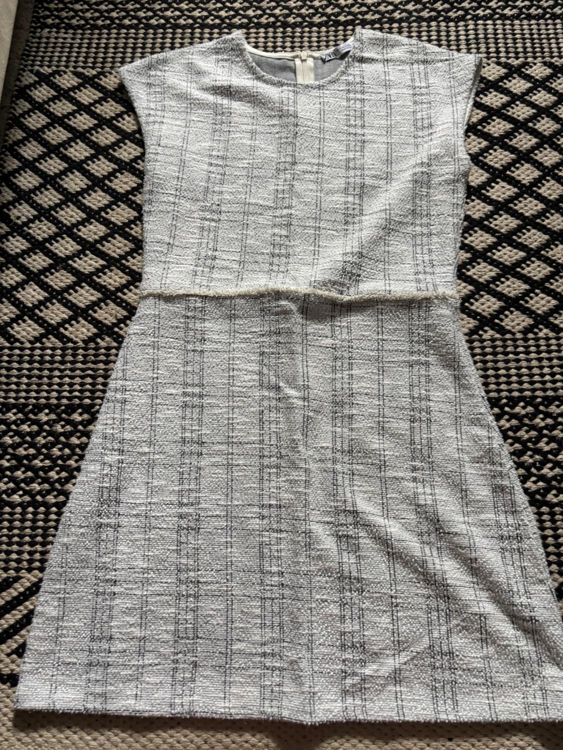 Front view of a white dress with a checked pattern and a back zip.