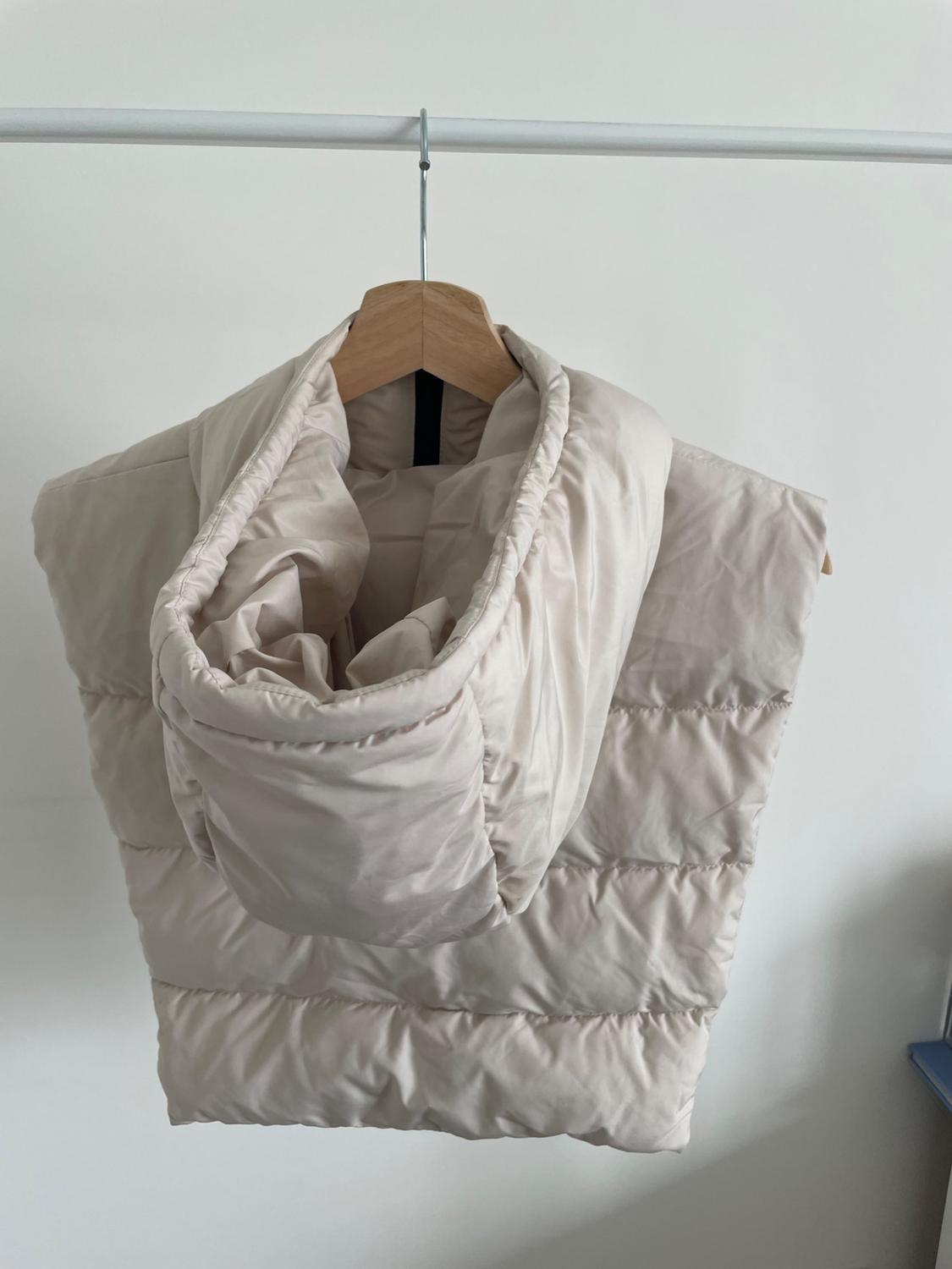 Close-up of hood and top of beige quilted jacket.