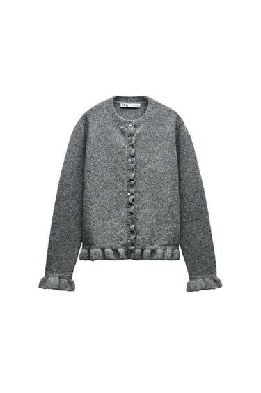 Front view of a grey jacket with buttons and a frill trim