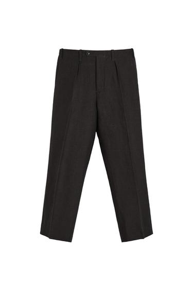 Front view of dark trousers with pleats and side pockets.