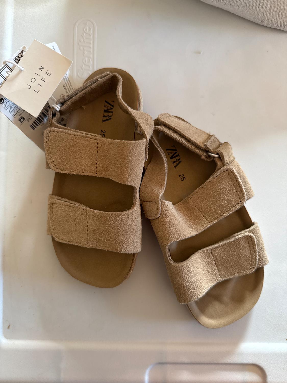 Beige strappy sandals with a fastening, "JOIN LIFE" label, and visible branding on the insole, on a white surface.