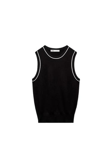 Black sleeveless knitted top with white trim on the neck and armholes against a white background. Visible ZARA label.