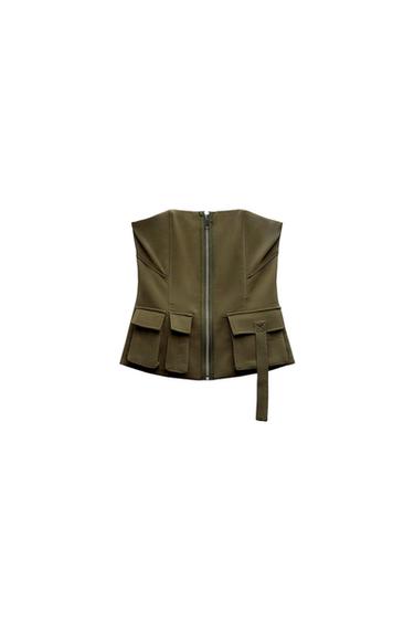 Olive green vest with front zipper, large pockets, and a dangling belt, on a white background.