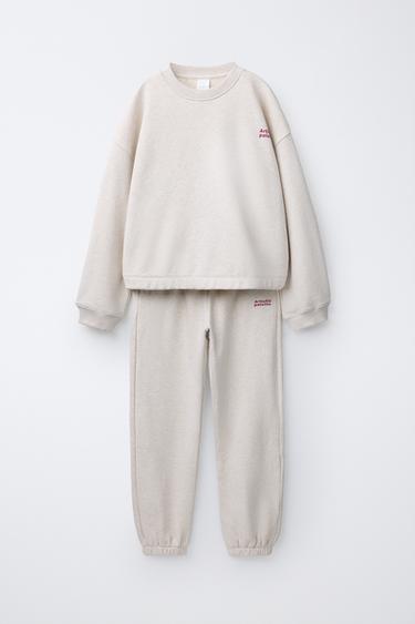 طقم سويت شيرت وبنطلون من صوف الخروف بكتابة - رملي /فيجوريه by Zara