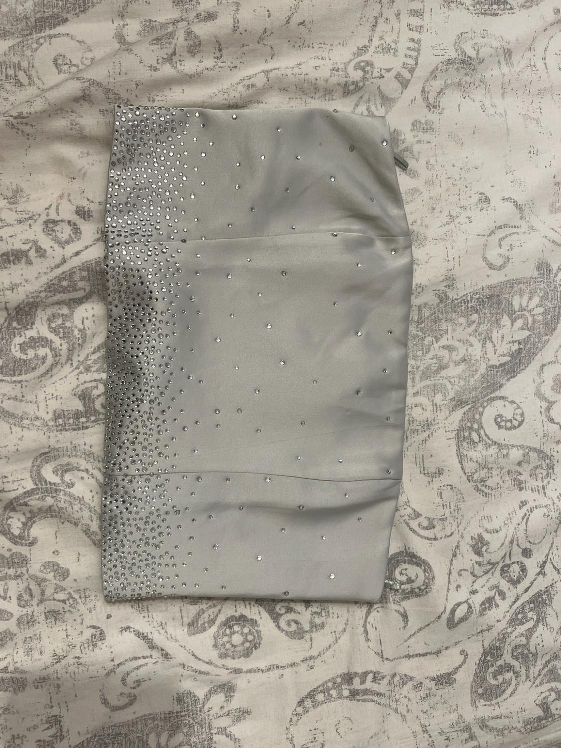 Light grey satin skirt with sparkling embellishments, photographed on a grey and white paisley print fabric.