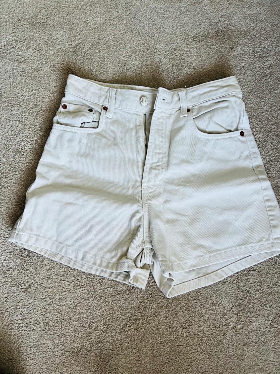 Front view of white shorts with front pockets and belt loops.