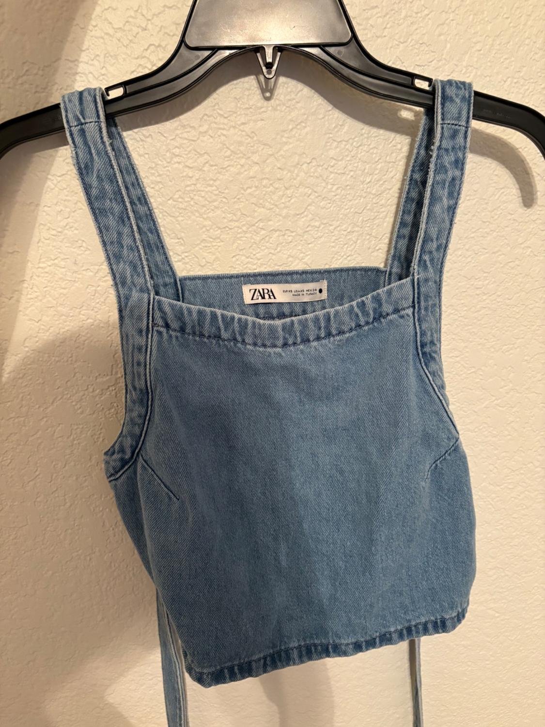 Front view of a blue crop top with wide straps and visible seams.