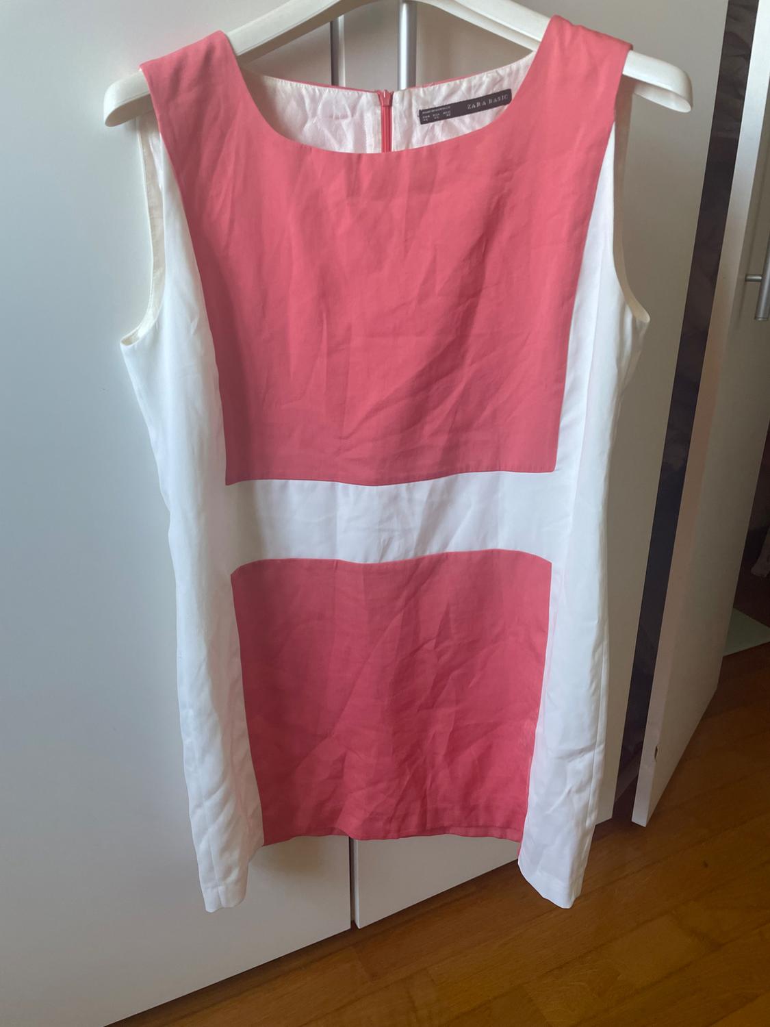 Front view of a white and pink sleeveless dress with a round neckline and a back zip.