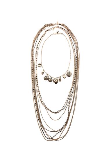 Three-pack of antique gold chain necklaces with beads and dangling charms. Lobster clasp closures.