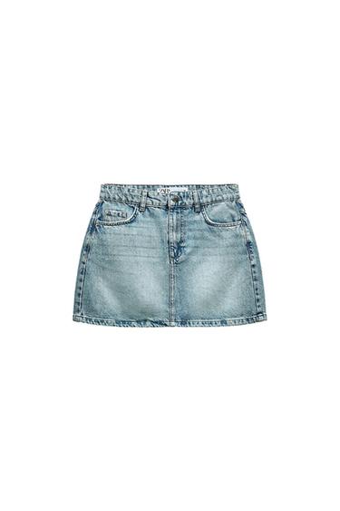 Light blue denim miniskirt with a washed effect, front pockets, belt loops and button fastening against a white background. ZARA label.