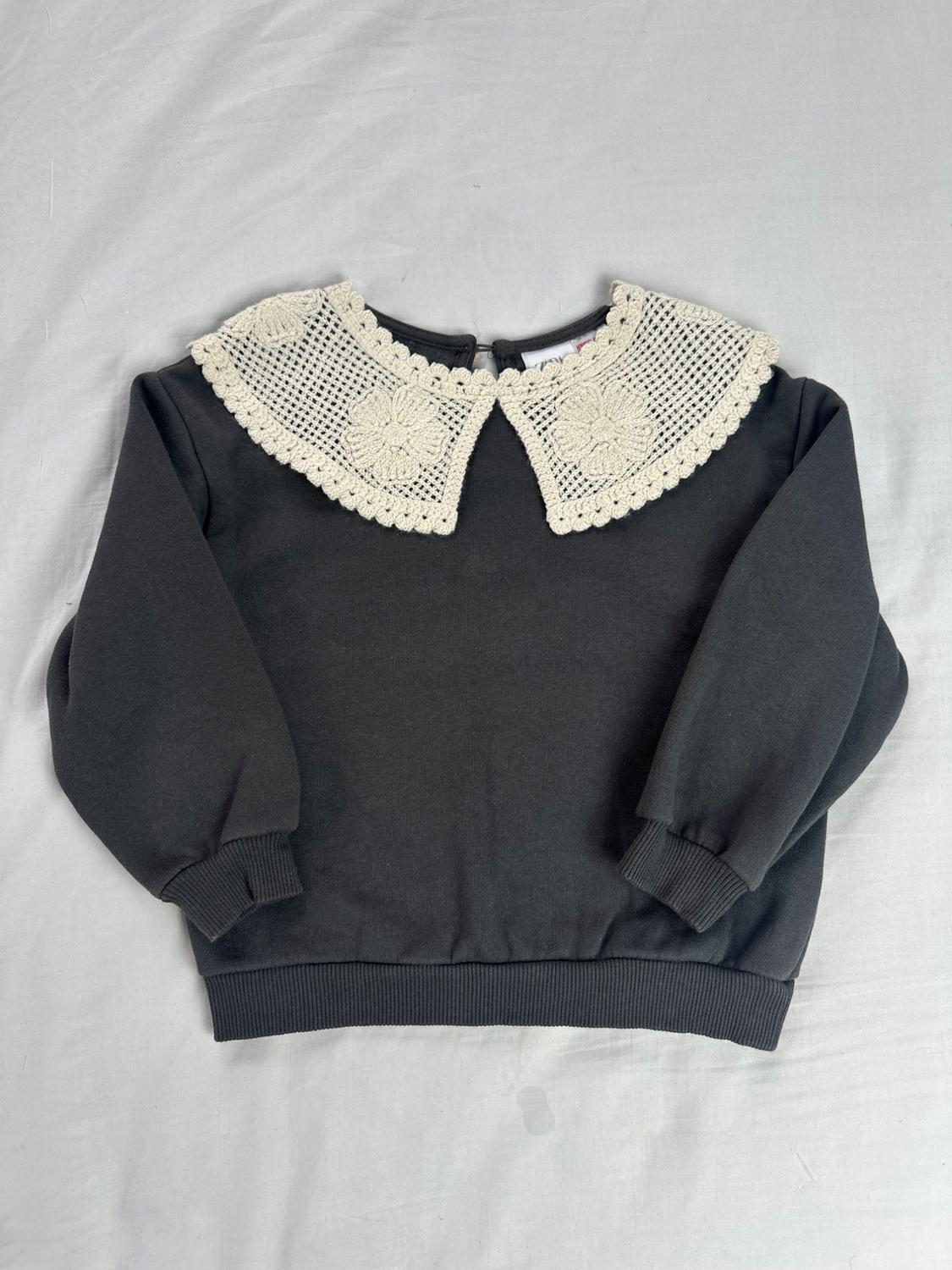 Dark gray long-sleeve hoodie with ribbed cuffs and a large cream crochet cowl collar with floral details.