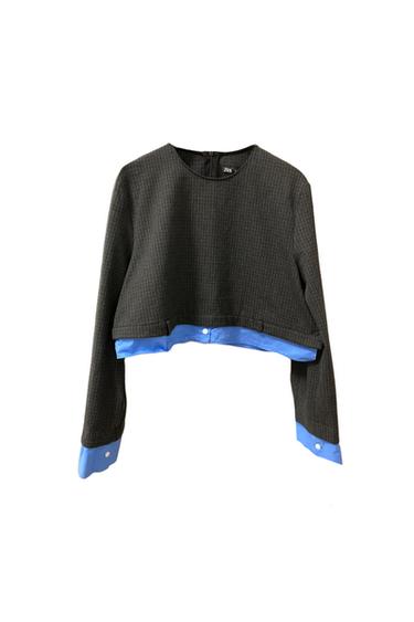 Textured grey crop top with blue detailing on the hem and cuffs. Back fastening. Visible label with "ZARA" text.