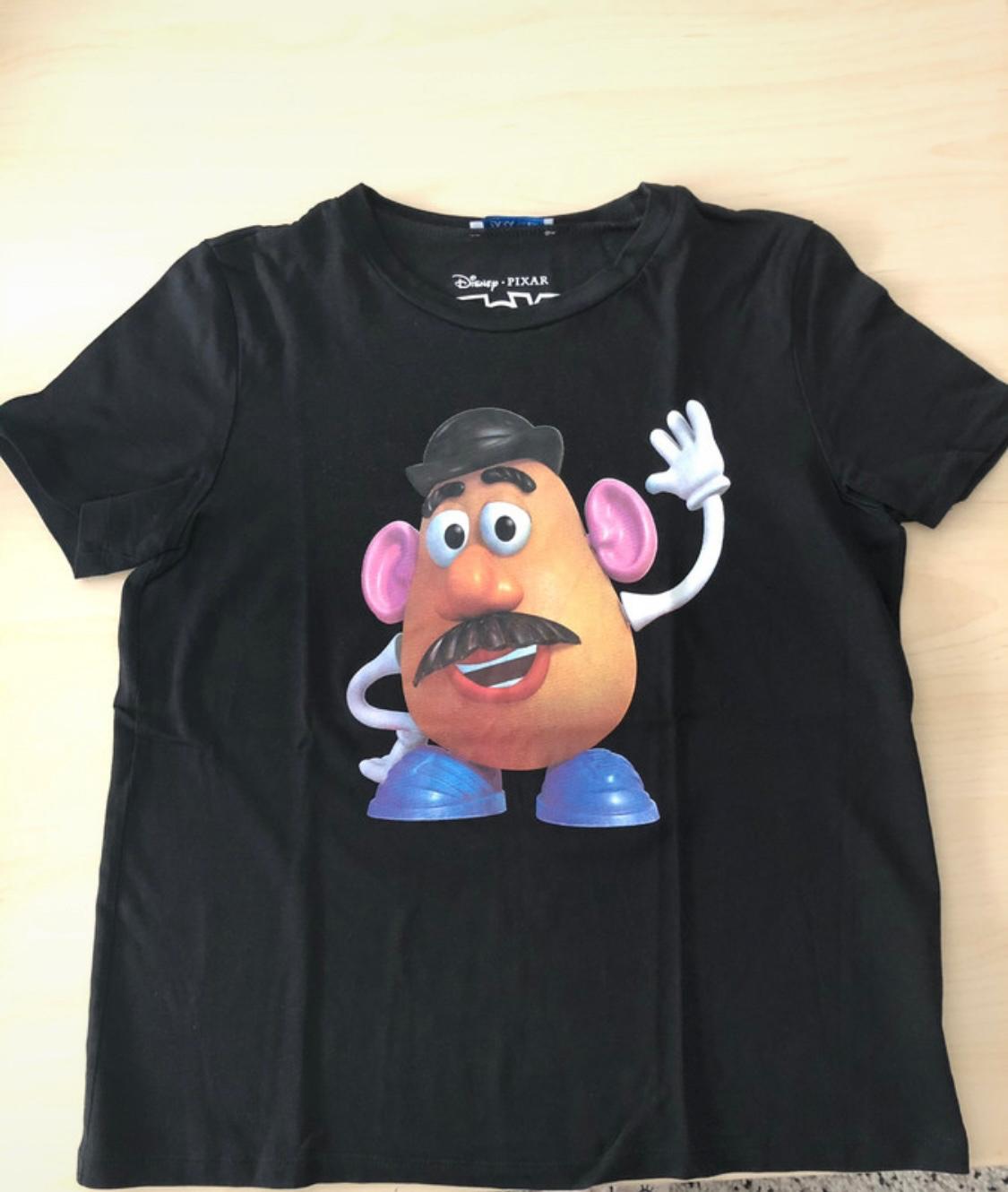 Black t-shirt with a picture of Disney Pixar's Mr. Potato Head, with a black hat, pink ears, and blue shoes.