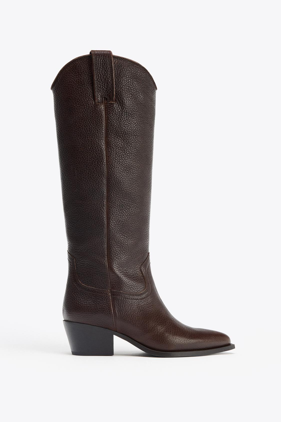 Side view of a brown knee-high boot with a low heel and visible stitching detail.