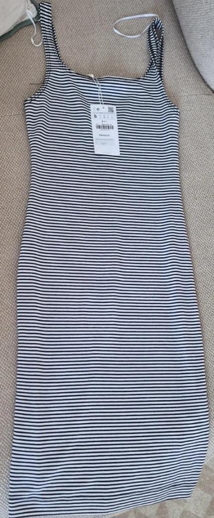Black and white horizontal striped bodycon cami dress. It has a tag and is laid out on a light-coloured fabric surface.
