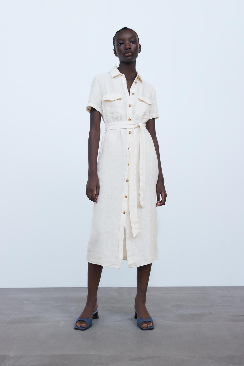 Linen dress. Lapel collar and short sleeves. Front patch pockets. Tied self belt. Front closure with contrasting buttons.