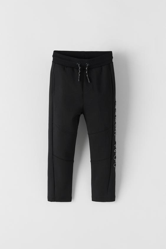 TROUSERS WITH EMBOSSED SLOGAN