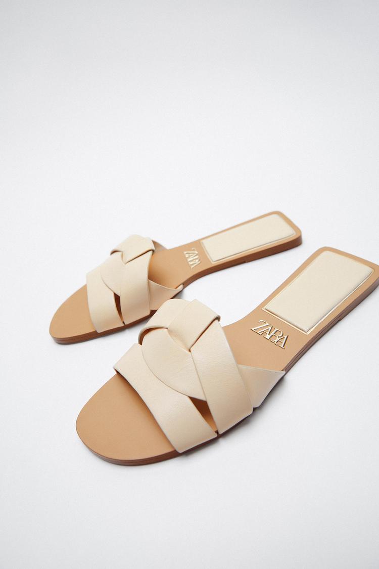 FLAT LEATHER SANDALS WITH CRISS-CROSS FRONT STRAP DETAILS.