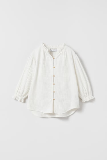 Image 0 of Textured oversized blouse with V-neck and long sleeves with elasticized trim. Front button closure. from Zara