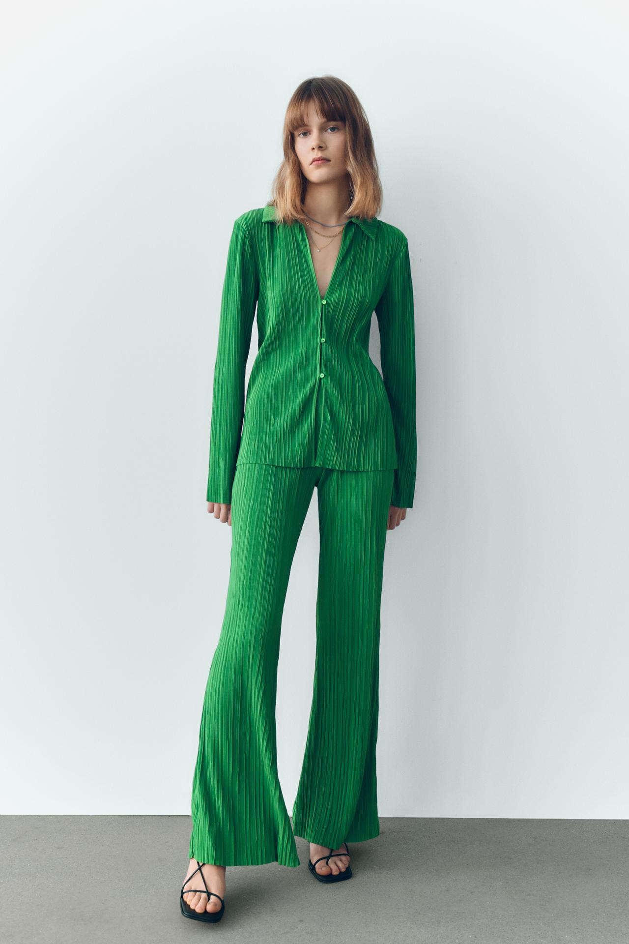 Bright Green Collared top from pleated fabric with a V-neckline and long sleeves. Front triple button fastening. Shown with coordinating green pleated trousers. 