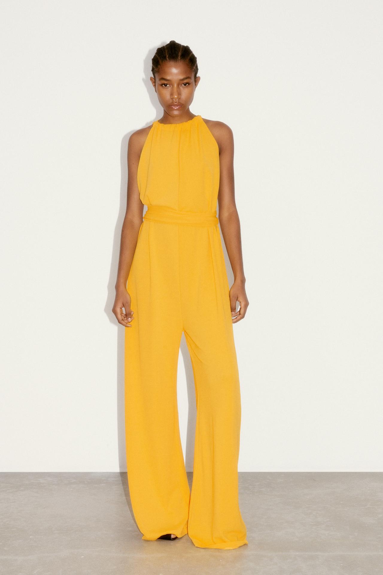 Mustard yellow Flowing jumpsuit with a round neckline and thin straps. Tied belt in the same fabric. Wide leg.